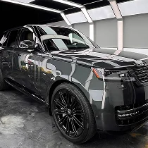 Black Range Rover SUV with glossy finish parked inside a professional detailing bay